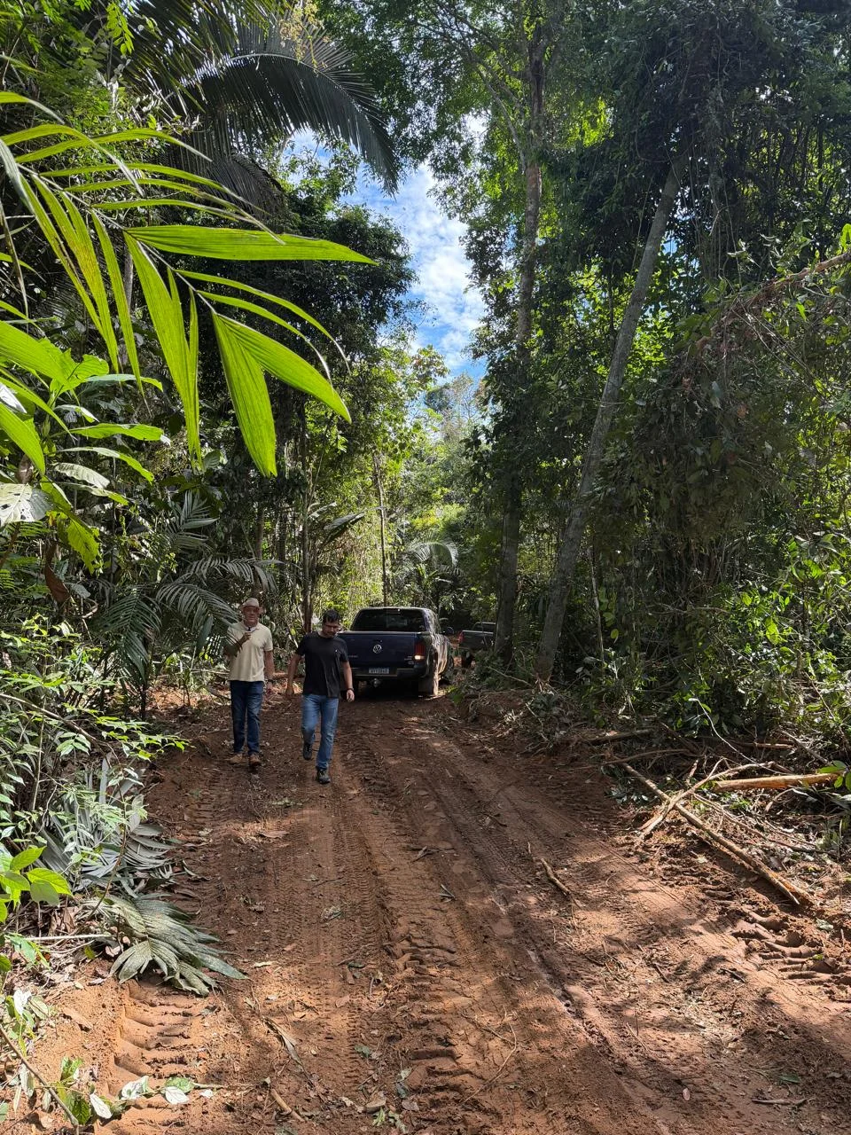 Equipe em estrada de terra dentro de área florestal no território do projeto
